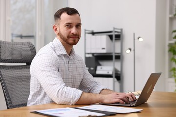 Man working on laptop at desk in office