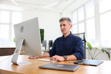 Businessman working with computer at table in office