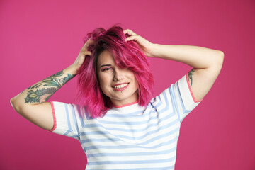 Fototapeta premium Beautiful woman with bright dyed hair on pink background