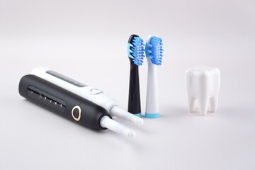 Modern electric ultrasonic toothbrush with rechargeable battery on a gray surface.