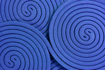 Obraz premium The arrangement of blue cobalt mosquito coils creates a distinctive, repeating circular patter green spiral background, resembling a yin-yang symbol