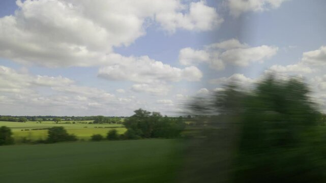 English countryside from a train window.
Fields and trees shot from a moving train window in the English Midlands.