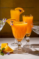 Refreshing orange juice cocktails garnished with edible flowers and orange slices