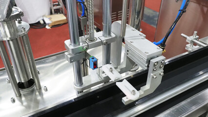 An automated capping machine on a conveyor belt.For high speed bottle and container packaging.