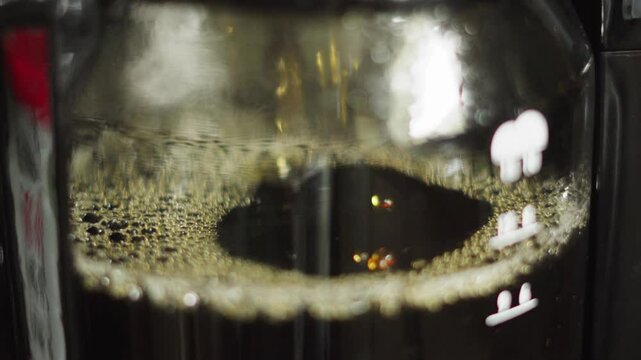 Side View of Coffee Dripping into Jug in Morning as Hot Water Passes Through Ground Beans Filter for Warm Morning Drink. Served at Home, Diners, Cafes.