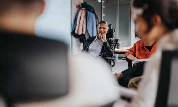 Business coworkers participating in a relaxed office meeting, showcasing collaboration and teamwork. The setting reflects a modern workspace environment fostering open communication and innovation.