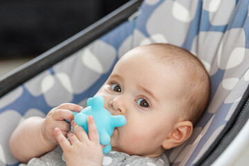 Close-up of baby chewing blue teething toy