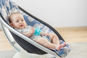Baby resting in rocker with blue teether