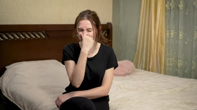 Woman holding her nose and grimacing from strong stench in room. Female covering nose, recoiling from foul odor in room. Woman wrinkling face and blocking nose due to unbearable smell at home