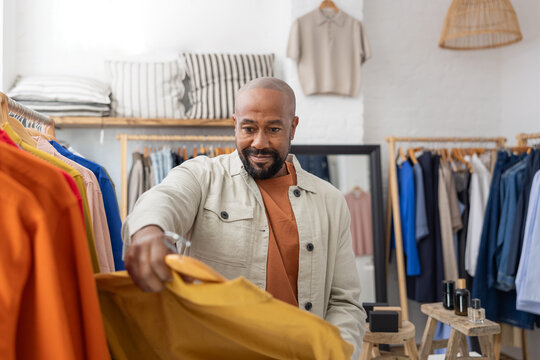 Man Selecting Colorful Clothing in a clothes store