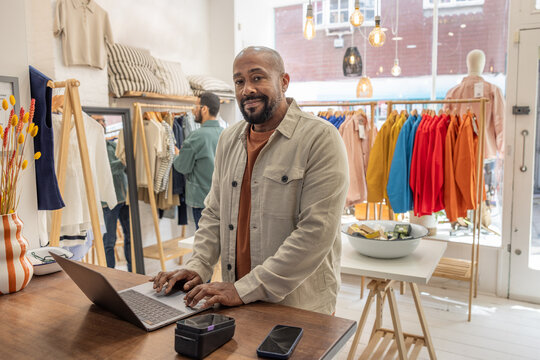 Boutique store owner using a laptop computer