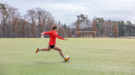 Girl on the soccer field. Soccer training. Active lifestyle. Football concept.