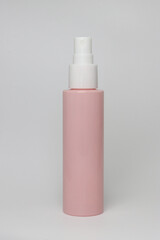 Pink container with a white syringe on top, spray bottle, for flowers and makeup, on a white background
