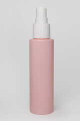 Pink container with a white syringe on top, spray bottle, for flowers and makeup, on a white background
