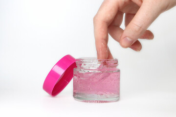 make up container with pink lid and gel pink product or cream and hand showing product