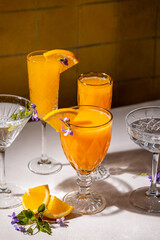 Refreshing orange cocktails garnished with edible flowers and orange slices