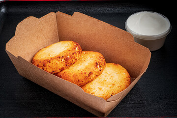 Delightful baked treats resting in a rustic container with a rich creamy dip on the side