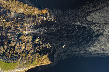 Beautiful foam patterns on water surface in river or sea, aerial drone view