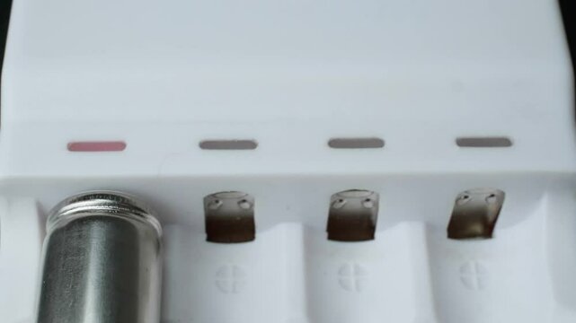 close-up of aa batteries charging in a white