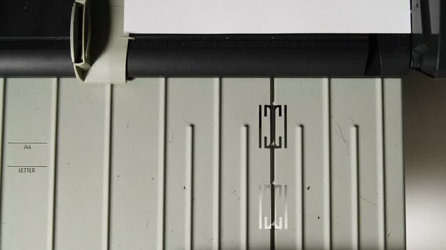 close-up of hand feeding white paper into an