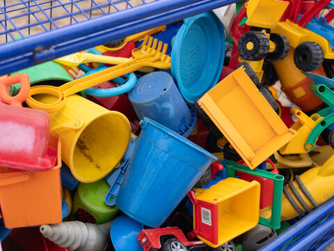 Kinderspielzeug f&uuml;r den Sandkasten im Kindergarten in Nahaufnahme in einer Blauen Gitterbox in Nahaufnahme
