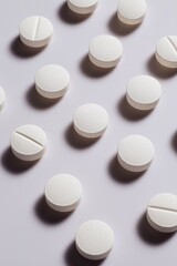Arrangement of white round tablets on light surface