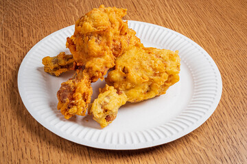 Juicy and crunchy fried chicken drumsticks served on a simple white plate, full of flavor