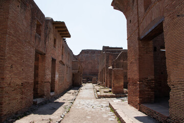 Ancient Roman brick buildings and ruins with a stone pathway in Ostia Antica archaeological site