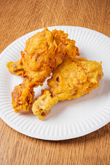 Crispy golden-brown fried chicken on a white plate, perfect for indulgence