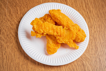 A plate with crispy chicken tenders awaits hungry diners during a casual meal setting