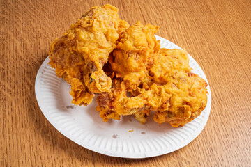 Fork-tender chicken pieces coated with a crunchy golden crust sit invitingly on a plate