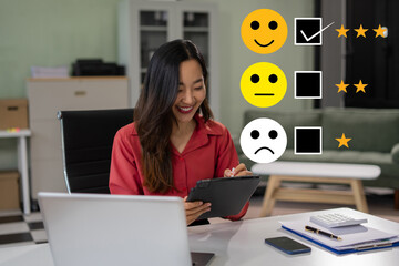 Woman holding a digital tablet with checkboxes rating smiley faces excellent for Satisfaction...
