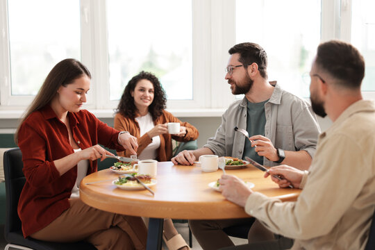 Colleagues chatting during lunch break in office