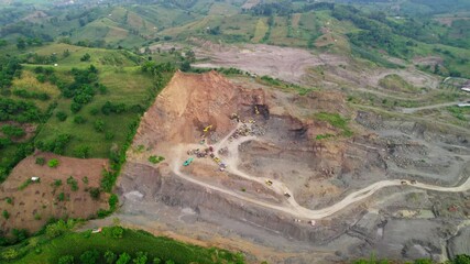Drone view of local open pit sand mining in Central Java, Indonesia. Mining activity cuts into the mountain