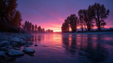 stunning sunset paints the sky in shades of purple and orange over a calm river. Silhouetted trees stand along the banks, creating a peaceful atmosphere in the early evening