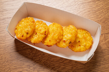 Five golden potato snacks arranged neatly in a cardboard container exude deliciousness