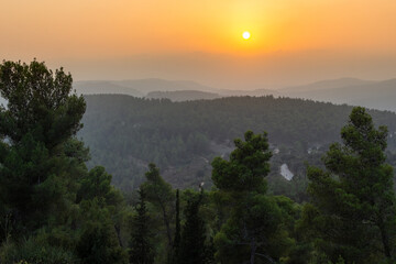 Sun setting over the rolling green slopes of the Judean hills west of Jerusalem, Israel