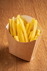 Freshly cooked fries nestled in a brown container create an inviting snack experience