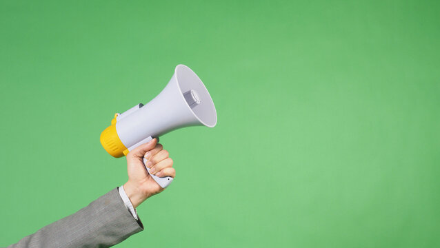 Hand is hold megaphone and wear grey suit on green screen background. - Powered by Adobe