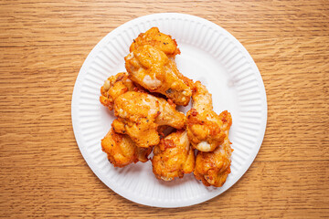 Fried chicken wings stacked high on a paper plate, perfect for casual gatherings!