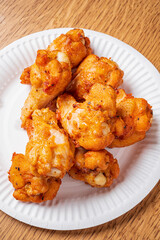 Deliciously crispy fried morsels are arranged on a disposable plate, tempting everyone nearby