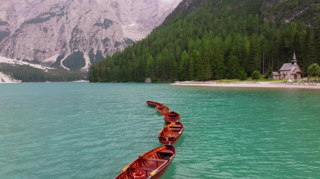Lago di Braies wooden rowing boats and surrounding, Lake Braies within the Fanes-Sennes-Braies Nature Park, Dolomites, Aerial closeup