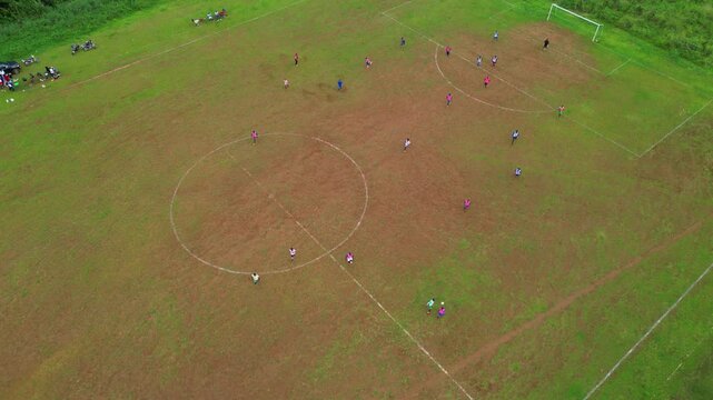 Bird's eye view of a football field with men playing with the ball at Trindade,São Tomé,Africa - Powered by Adobe