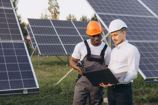 Engineers Examining Solar Panel Efficiency with Digital Technology