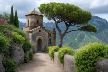Naklejka premium Stone path leads to an aged building beneath a sprawling tree with mountains in the backdrop