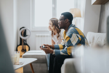 A diverse couple spending quality time playing video games, seated on a cozy sofa in a modern living room. The warm lighting and casual atmosphere capture the essence of leisure and connection.