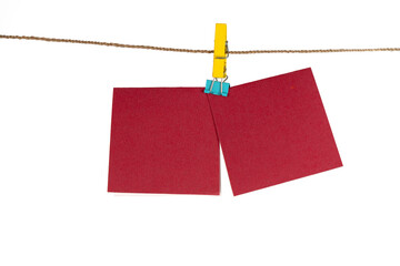 Two pieces of red rectangle paper hang on a rope