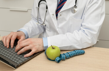 A dietitian sits at a computer and prepares a menu.