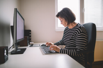 Elderly woman is typing on the keyboard