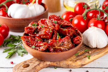 Homemade sun-dried tomatoes in olive oil, gourmet italian food ingredient, with fresh tomatoes, oil...